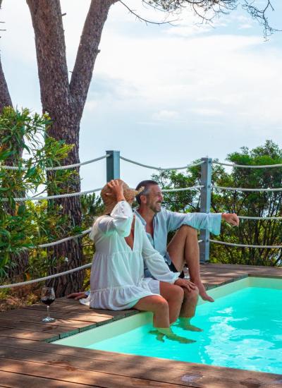 Relaxed couple by the pool with sea view.
