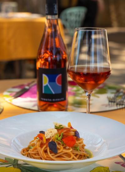 Elegant spaghetti with rosé wine, a refined outdoor dining experience.