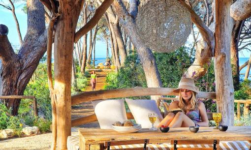 Relaxed woman reading in a natural setting with sea view.